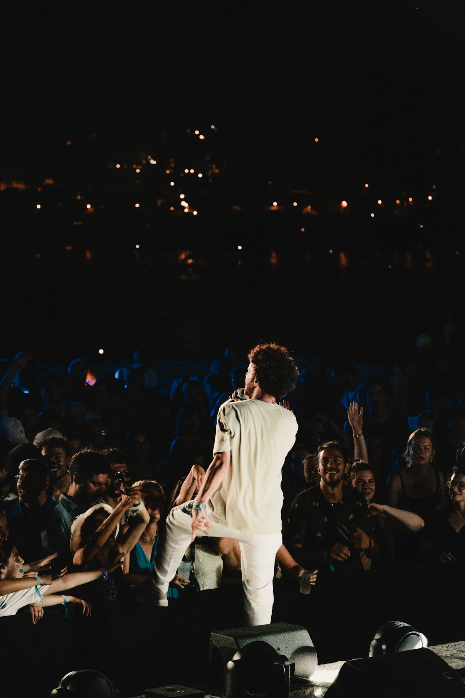 A performer facing the audience at a nighttime concert
