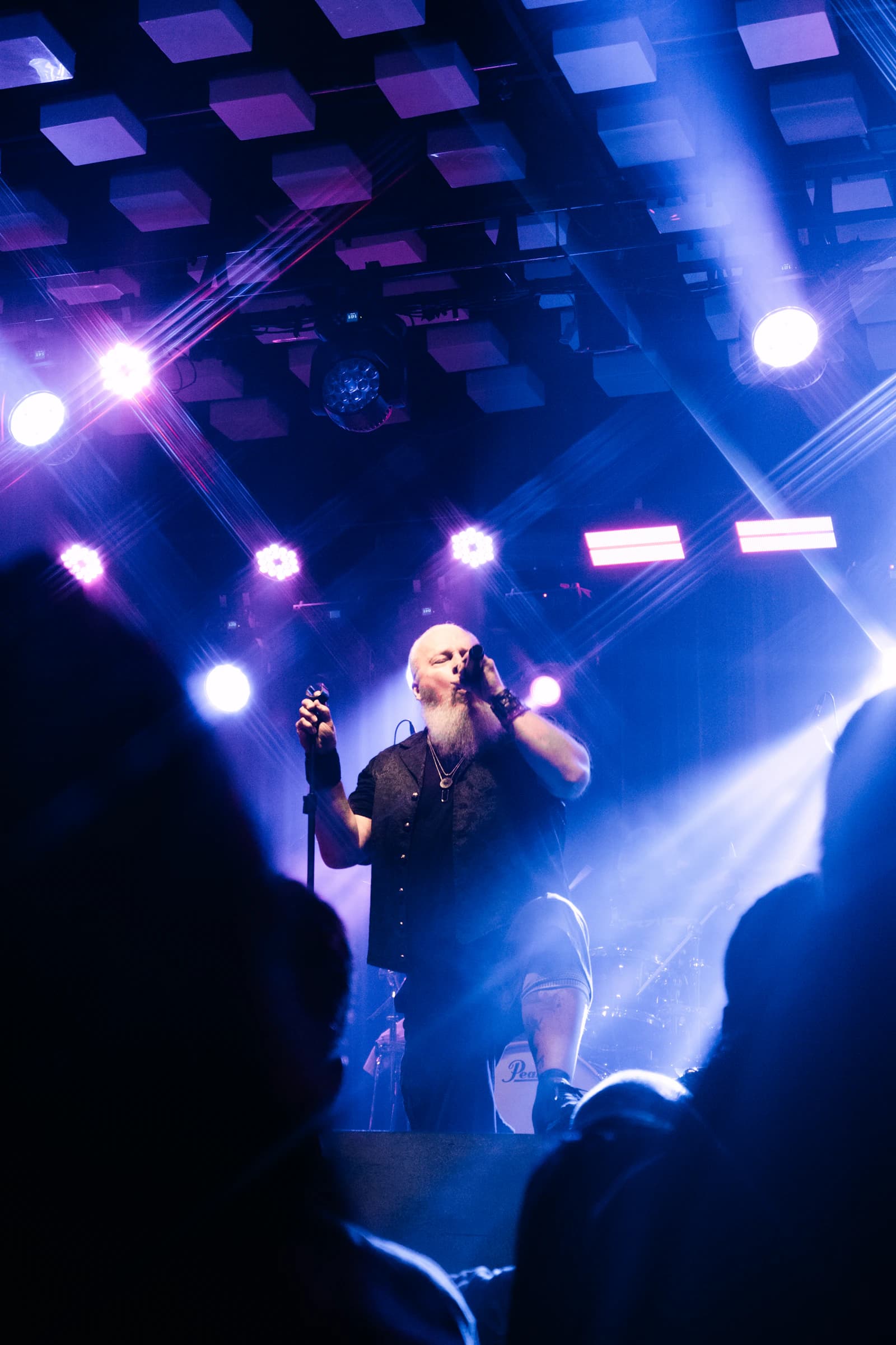 A singer performing under blue and purple stage lights